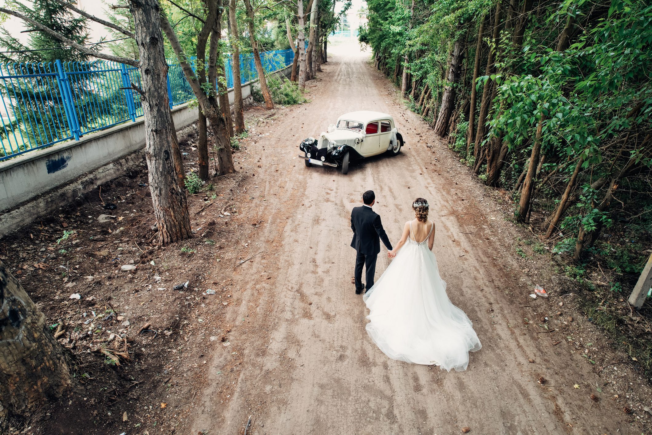 Couple in wedding attire on forest path